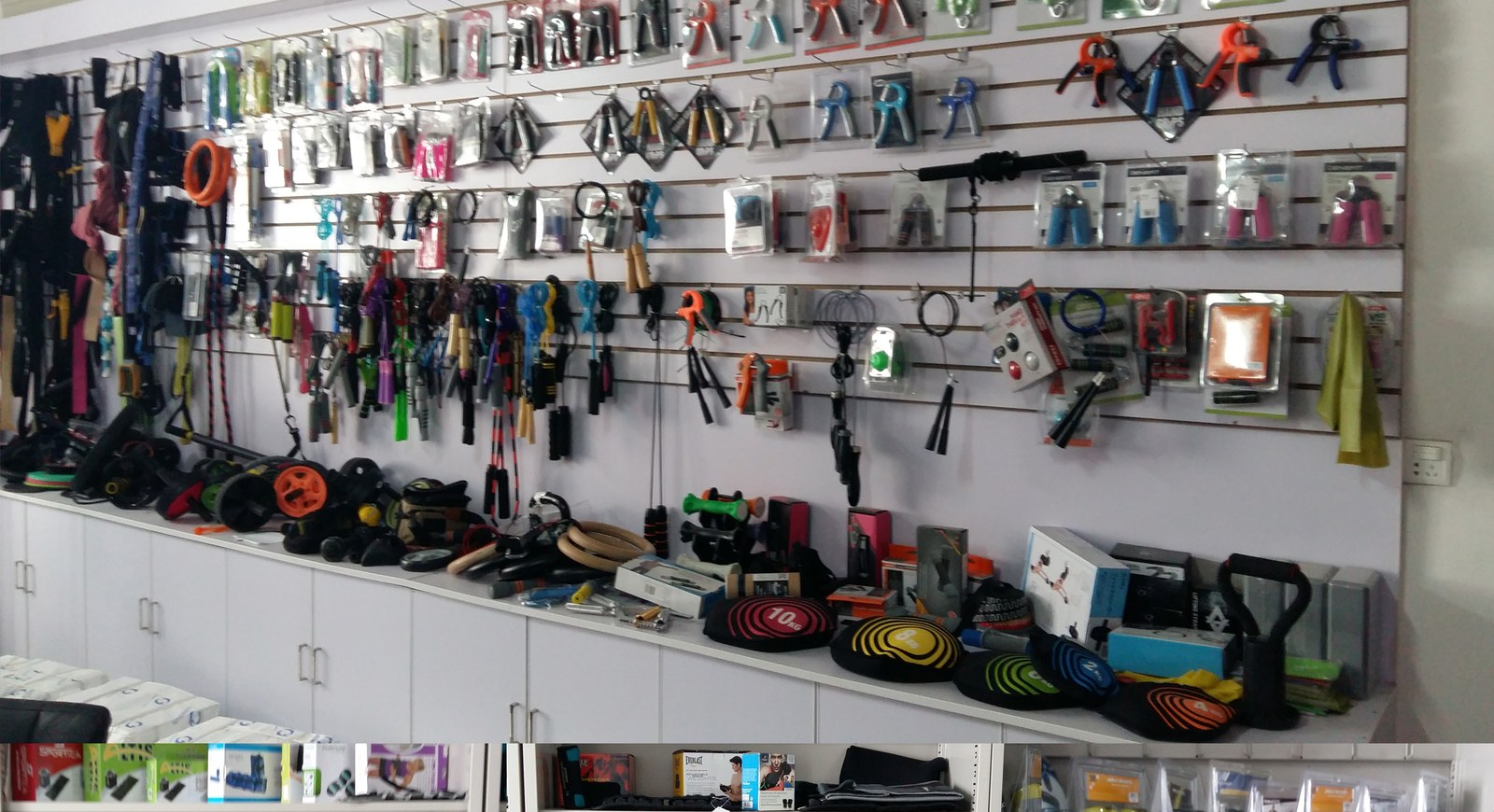 About UnivFitness Wall display of fitness accessories samples - resistance bands hand grips jump ropes - in UnivFitness showroom